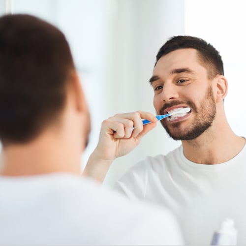 man-toothbrush-cleaning-teeth-bathroom
