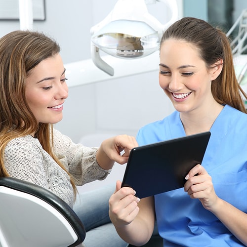 Patient pointing at the screen while the nurse holds tablet 